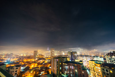 Illuminated cityscape against sky at night