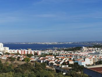 High angle view of townscape by sea against sky