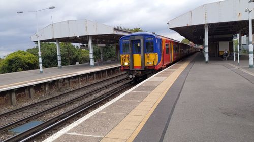 Train at railroad station platform against sky