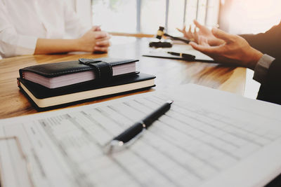 Cropped image of man reading book on table