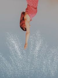 Low section of woman walking on water against gray background