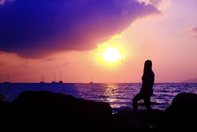 Silhouette people on beach against sky during sunset