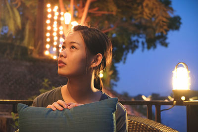 Portrait of young woman looking away against sky