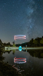 Light painting on lake against sky at night