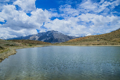 Scenic view of lake by mountains against sky