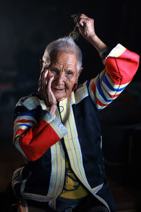 Portrait of smiling man standing against black background