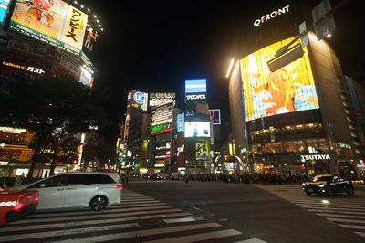 Cars on illuminated street at night