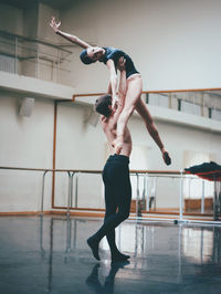 Full length of dancers dancing in ballet studio