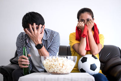 Friends watching sports on tv while sitting at home