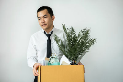 Portrait of businessman using digital tablet while standing against white background