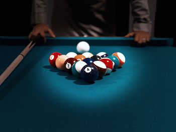 Close-up of pool table with man in background