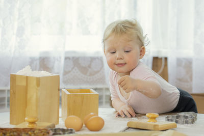 Portrait of cute boy preparing food on table at home