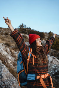 Young woman wearing hat standing against sky