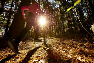 A woman trail running up a hill.