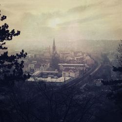 View of cityscape against cloudy sky