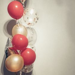 Multi colored balloons hanging on wall at home