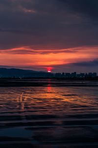 Scenic view of dramatic sky over lake during sunset