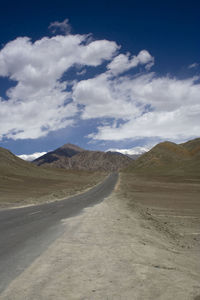 Scenic view of road by desert against sky