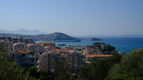 High angle view of townscape by sea against clear sky