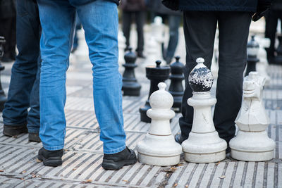 Low section of man standing on chess