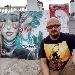 Portrait of young man with graffiti on wall