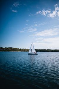 Sailboat sailing on sea against sky