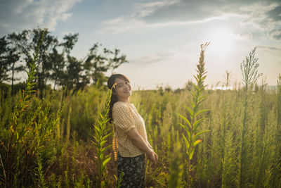 Woman standing on field against sky