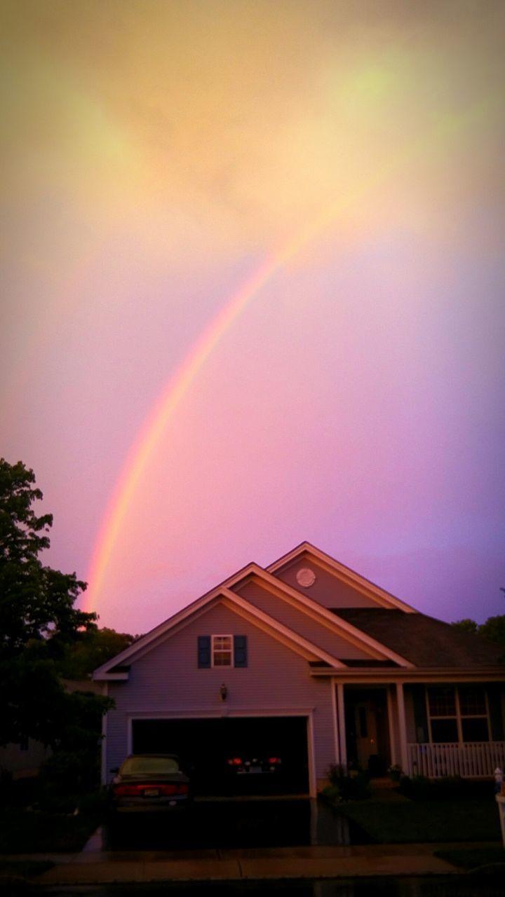 LOW ANGLE VIEW OF RAINBOW OVER HOUSES