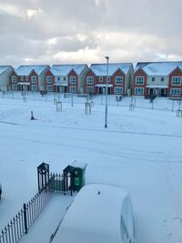 Houses on snow covered landscape against sky