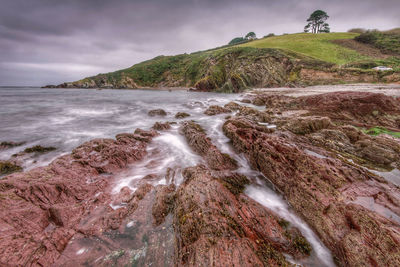 Scenic view of rocks in sea against sky