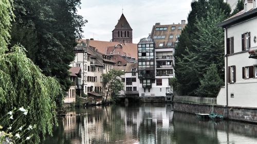 Buildings by trees against sky