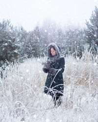 Portrait of woman in snow on field
