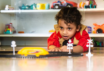 Cute boy playing with toys at home