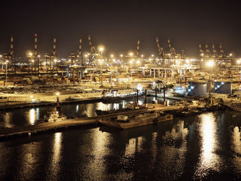 High angle view of illuminated harbor against sky at night