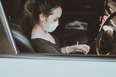 Cinematic style of young women in the car on driver position and prepare to start engine