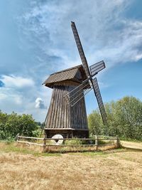 Traditional windmill on field against sky