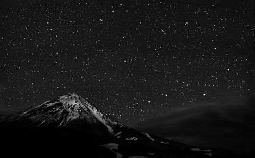 Scenic view of snowcapped mountains against sky at night