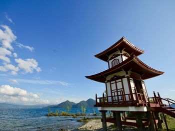 Traditional building on beach against sky