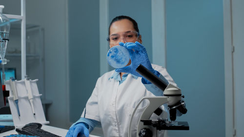 Portrait of doctor holding dentures in laboratory