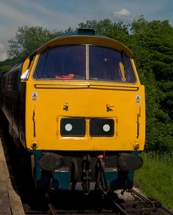 Close-up of yellow car against sky