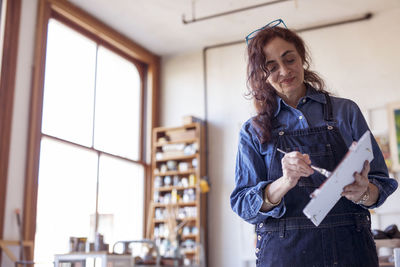 Low angle view of female artist working in workshop