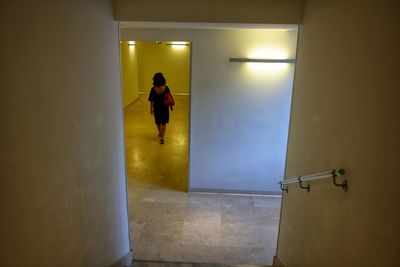 Rear view of woman walking in underground walkway