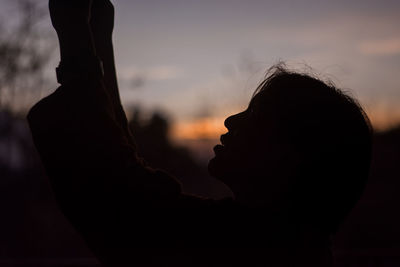 Close-up of silhouette woman against sky during sunset