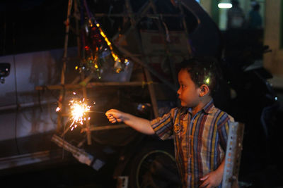 Boy looking at illuminated christmas lights at night
