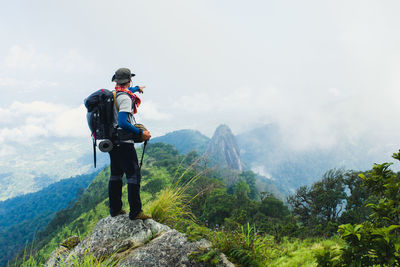 Full length of man looking at mountains against sky