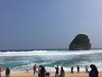 People at beach against sky