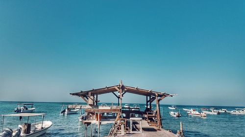 Lifeguard hut on beach against clear blue sky