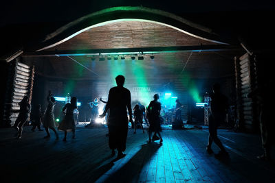 Silhouette people in illuminated tunnel