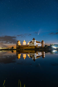 Comet neowise in a night landscape. mir castle in belarus. astronomy. 