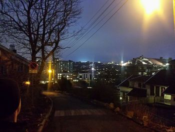 Road passing through illuminated city at night